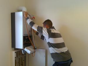 a Sugar Land plumber checks a water heater unit