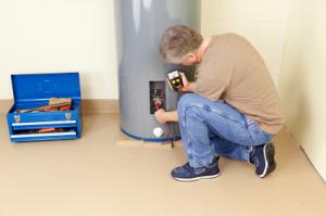 a Sugar Land water heater repair tech is investigating the unit